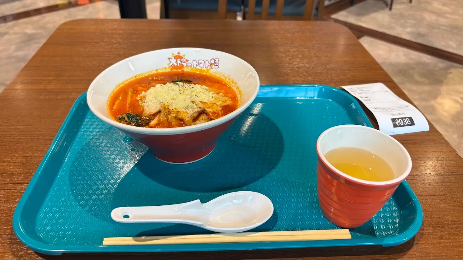 太陽のトマト麺橿原アルル店で提供される「太陽のチーズラーメン」。真っ赤なトマトスープの上にたっぷりチーズがトッピングされている様子