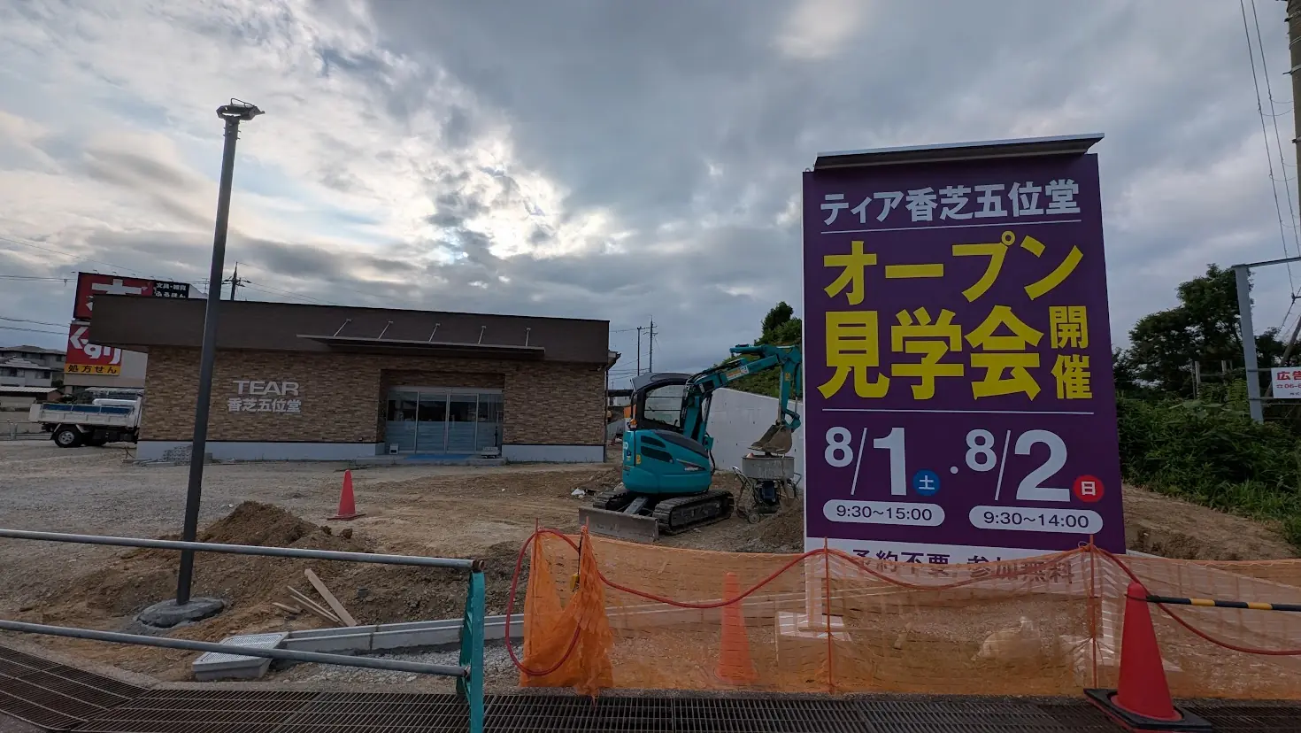 建設中の「家族葬のティア香芝五位堂」と、8月1日・2日に開催されるオープン見学会を告知する看板