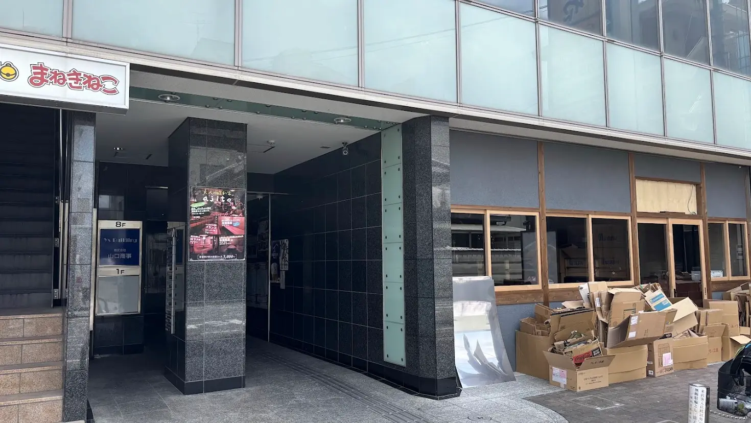 大和八木駅近くの改装工事現場。店舗の入り口付近には大量のダンボールが積まれ、ガラス越しに見える店内奥にもさらに段ボールが山積みになっている様子