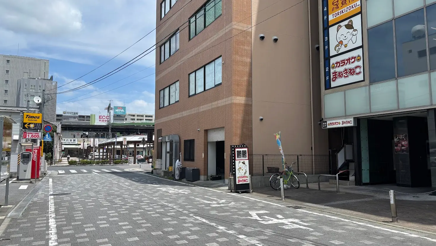 大和八木駅方面を向いた風景。右手にはテナントビル、左手にはタイムズ駐車場があり、正面奥には大和八木駅が見える