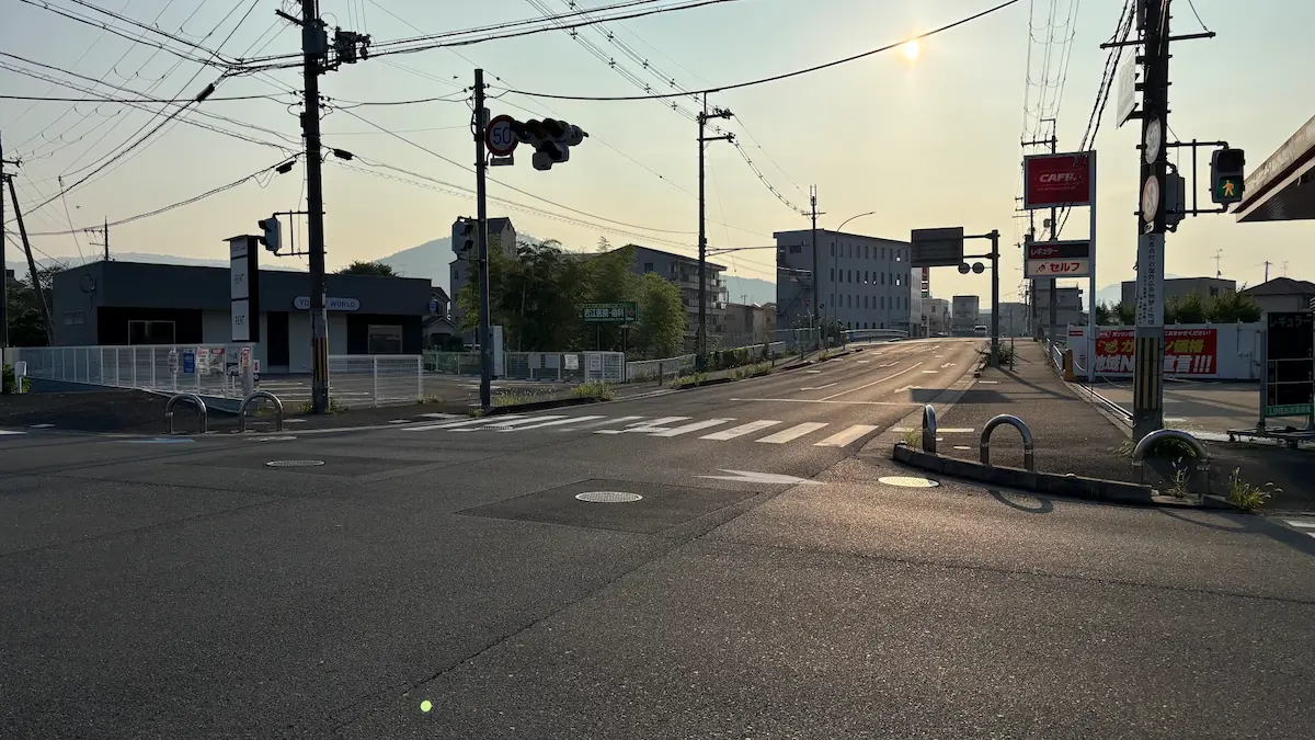 桜井方面へと続く道路の風景。右手にはCAFILのガソリンスタンドの看板と「ガソリン価格地域No.1宣言！！」の大きな垂れ幕が掲げられている
