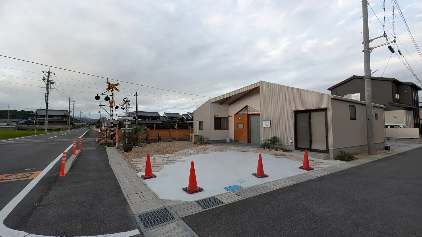 8月末日〜9月初めオープン予定の「Cafe ゆるり」の店舗外観と、そのすぐ脇に位置する踏切や周辺の道路環境の様子。