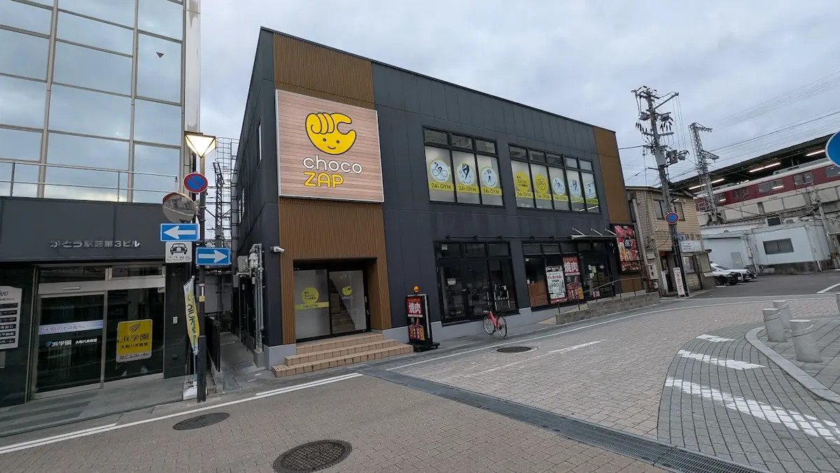 大和八木駅近くの「ひとくち餃子の頂」向かいに位置する、黒と木目調のシックな外観が特徴的な「chocoZAP（チョコザップ）」の店舗。