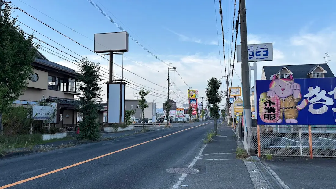青空の下、奈良県橿原市内の道路沿いに立つ「はるやま」の大型看板と、9月中旬オープン予定の「HODAKA(ホダカ)」店舗から橿原市内方面を見たロードサイドの景観。