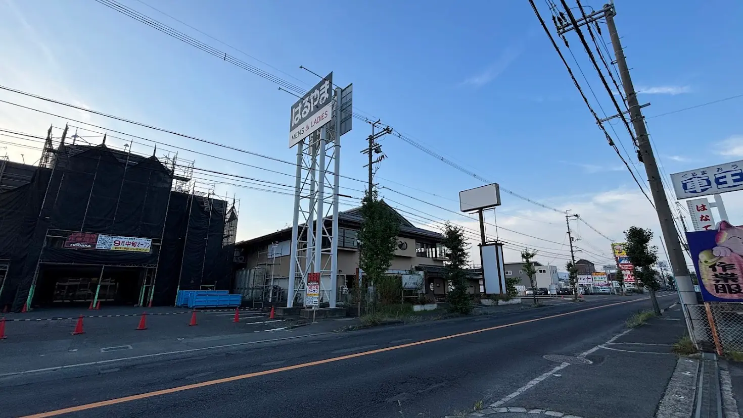 青空の下、奈良県橿原市内の道路沿いに立つ「はるやま」の大型看板と、9月中旬オープン予定の「HODAKA(ホダカ)」の告知が掲げられた工事中の店舗外観。