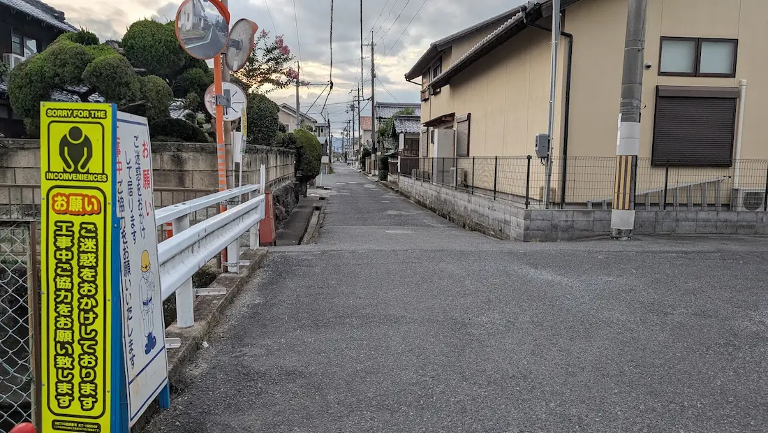 広陵町の住宅街にある工事中の看板が置かれた細い道路。ホームセンターダイキ方面へ抜ける車道の様子。