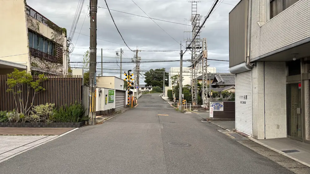 南八木交差点を曲がった先にある、踏切と狭い車道が続く周辺の道路環境の様子。