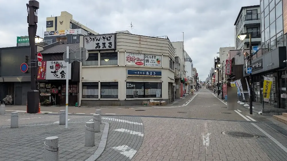 大和八木駅近くの「ひとくち餃子の頂」付近から見た、「四季彩宴 あまき」や飲食店、セブンイレブンなどが並ぶ駅前の街並みの様子。