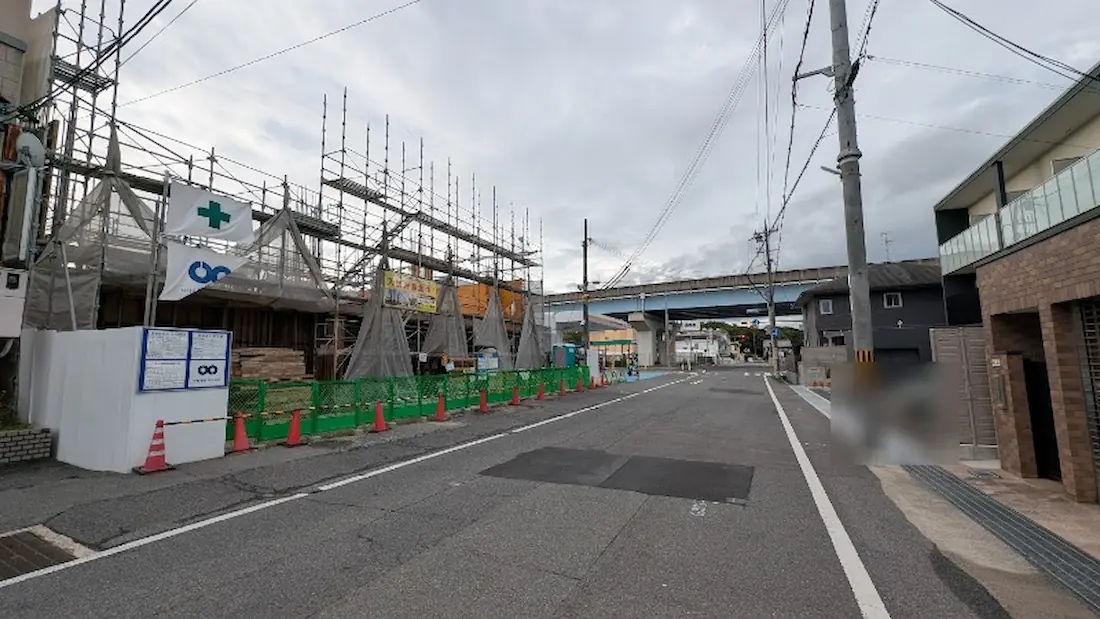 橿原市四条町のマンション建設現場付近から、高田バイパスの高架やガソリンスタンド、四条町西交差点方面を見渡した道路の様子。