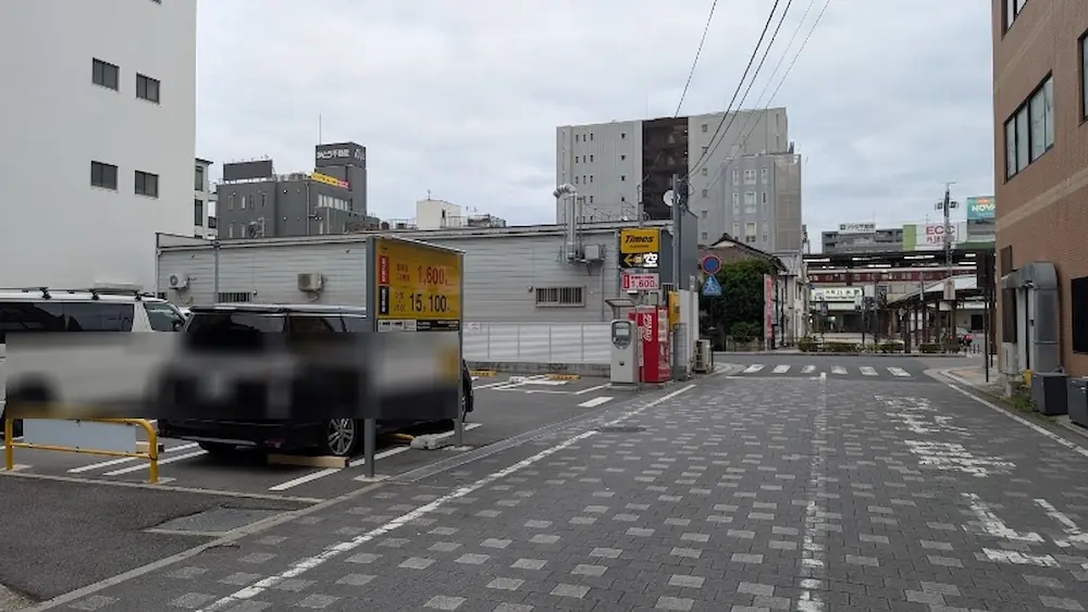 大和八木駅近くにあるコインパーキング「タイムズ大和八木駅前」の全景。駐車スペースや料金看板、石畳の周辺道路の様子。