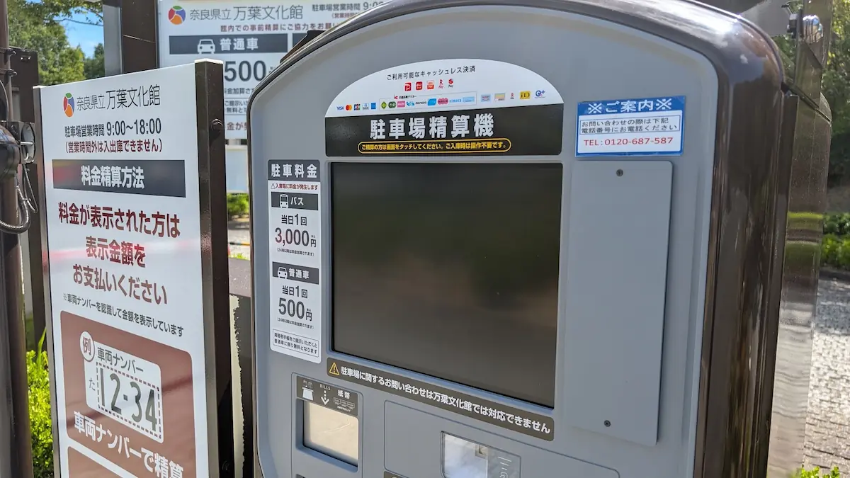 奈良県立万葉文化館の駐車場に設置された精算機のアップ。画面上部にクレジットカード、電子マネー、各種QRコード決済などの対応ブランドロゴが並んでいる様子。