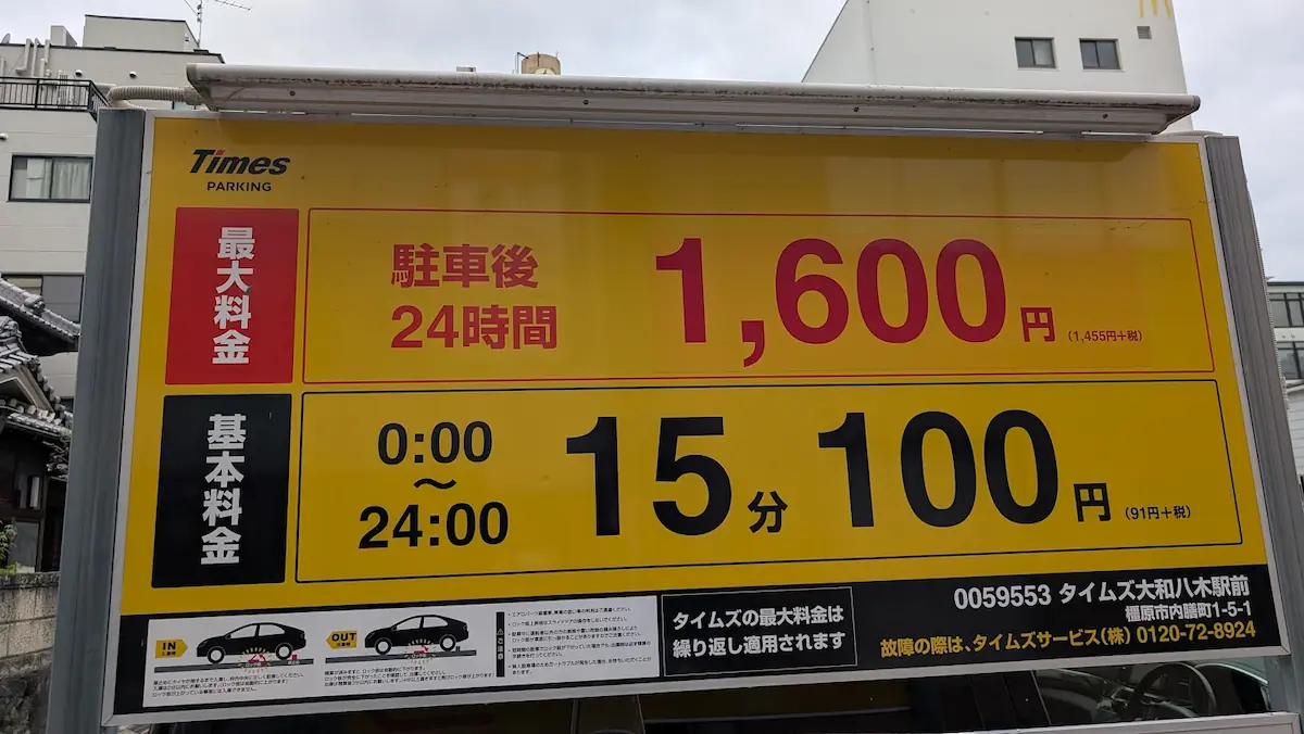 「駐車後24時間 最大1,600円」「15分100円」などの駐車料金の詳細や最大料金の繰り返し適用について掲示された「タイムズ大和八木駅前」の料金看板。