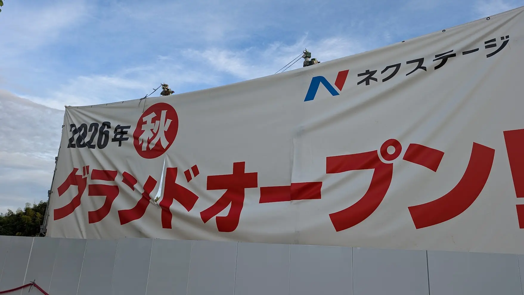 Chuwa Kansen沿いの建設現場に掲げられた、「2026年秋グランドオープン！」と大きく書かれたネクストステージの横断幕の様子。