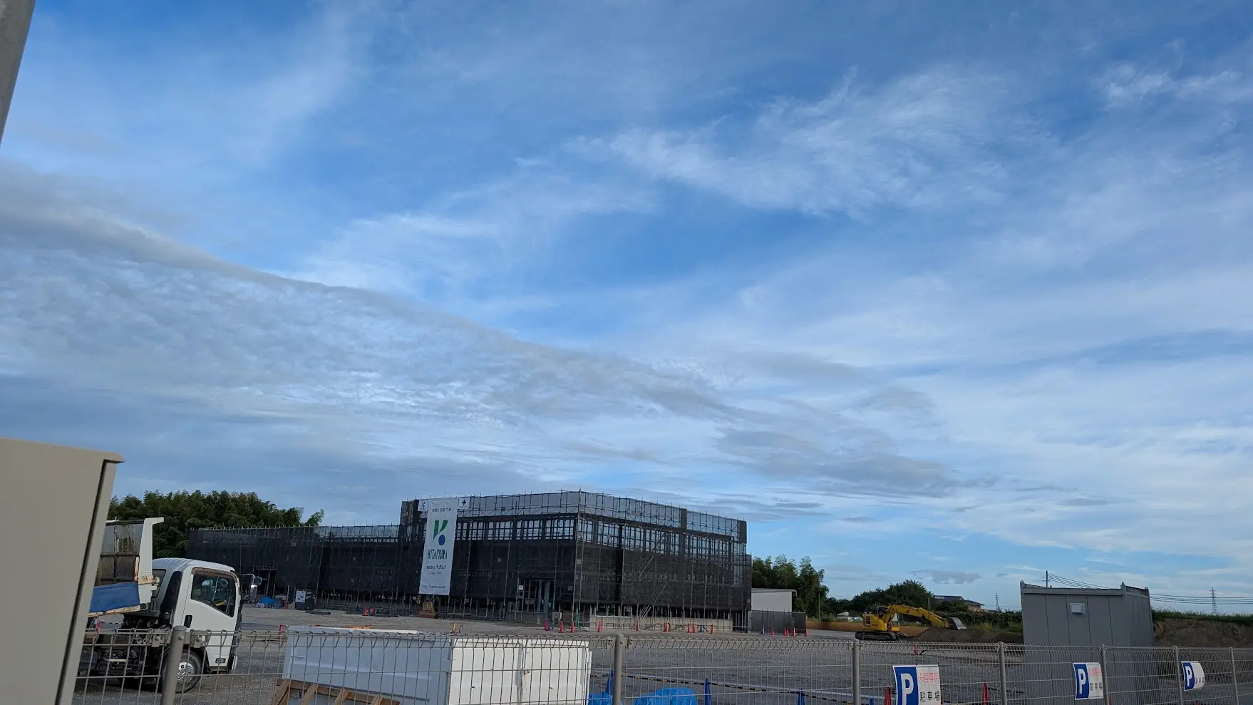 青空の下、Chuwa Kansen沿いで2026年秋のオープンに向けて建設工事が進む「ネクストステージ」の建物全体と工事現場の様子。