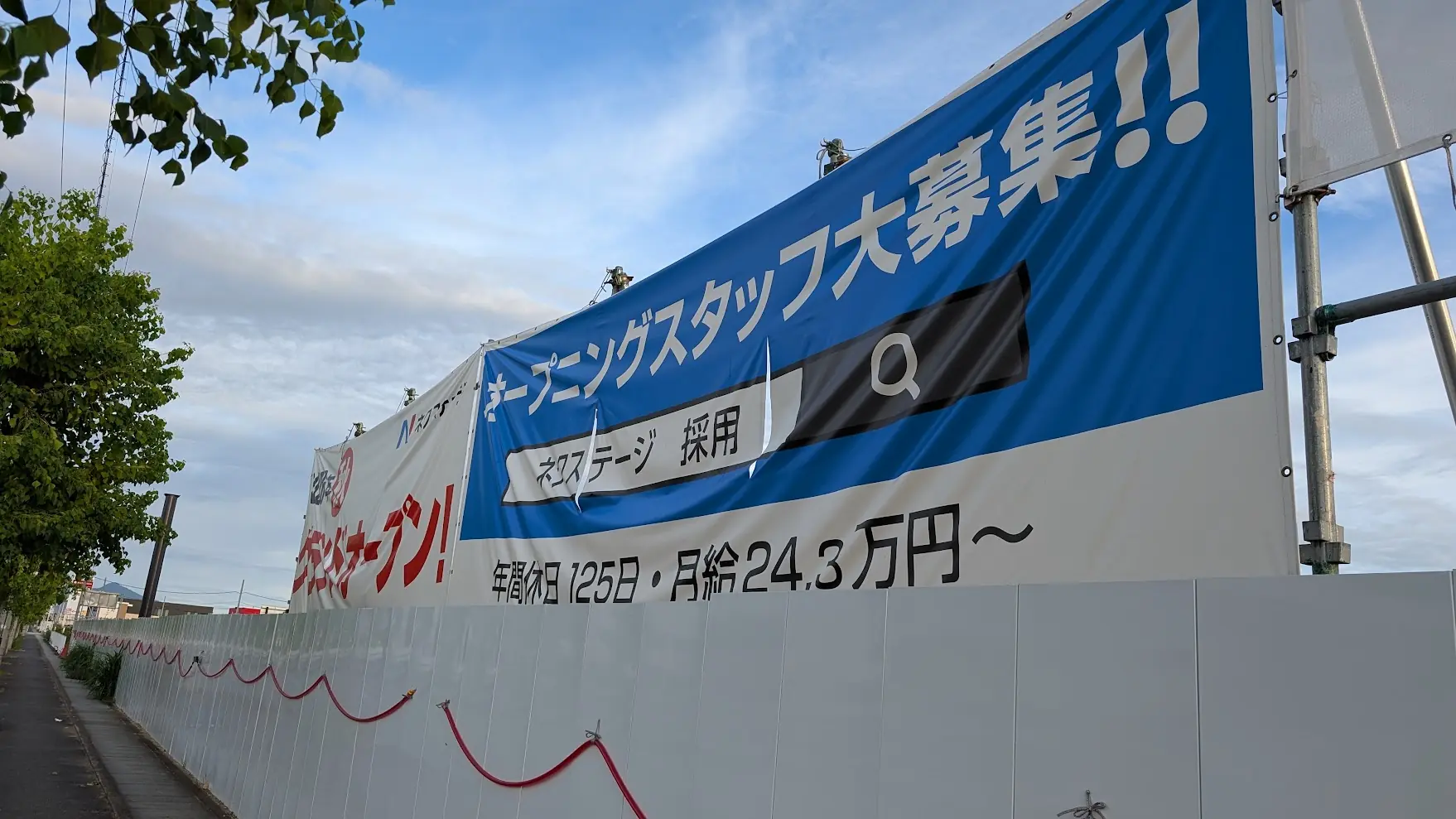 Chuwa Kansen沿いの建設現場に掲げられた、「オープニングスタッフ大募集！！」と記されたネクストステージの採用情報横断幕の様子。