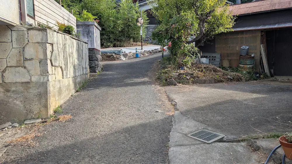 飛鳥村において、案内アプリに従って進んだ先にある、民家の間を通る極狭の行き止まりの道路の様子。