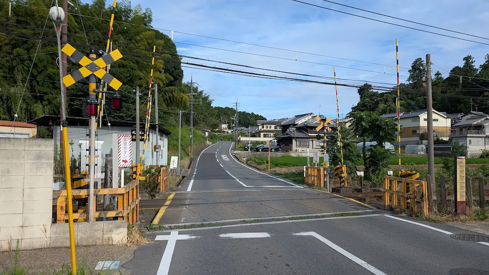 飛鳥駅から星のや飛鳥へと向かう徒歩ルートの途中、踏切を渡った直後に上り坂が続く道路の様子。