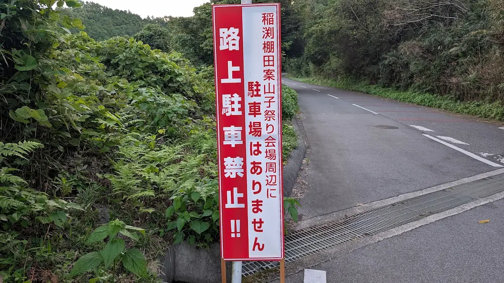 稲淵の案山子祭り会場周辺において「駐車場はありません 路上駐車禁止！！」と警告する赤と白の現地の看板。