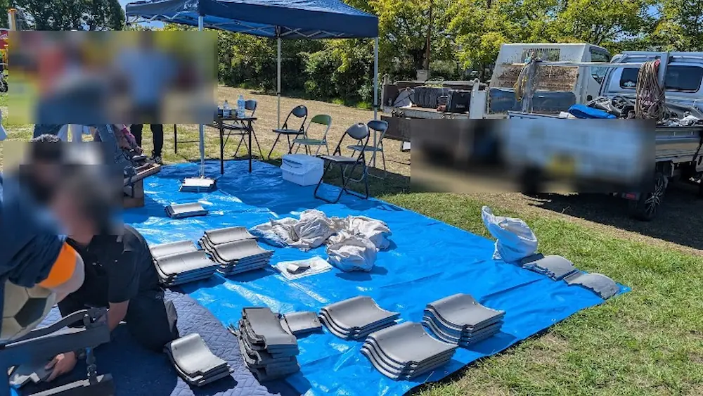 竹取公園のほほえみフェスタ会場で、青いシートの上で瓦の加工や職人のお仕事体験を楽しんでいる様子。