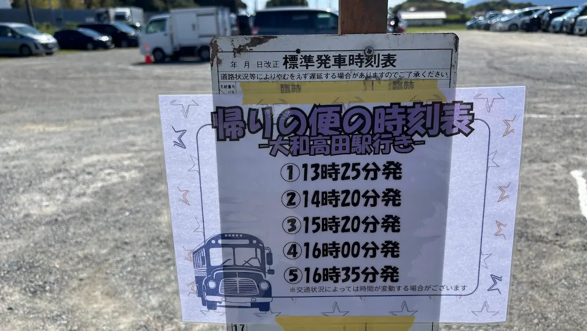 竹取公園のほほえみフェスタ会場に掲示されている、大和高田駅行き臨時バスの「帰りの便の時刻表（13:25発、14:20発、15:20発、16:00発、16:35発）」の様子。